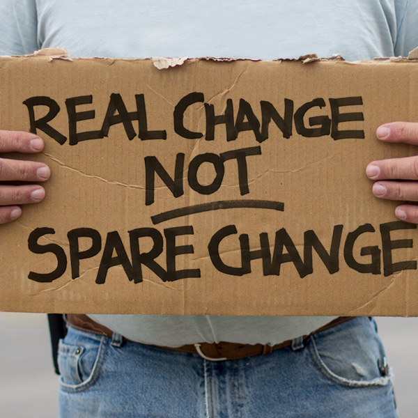 Homeless man holding cardboard sign